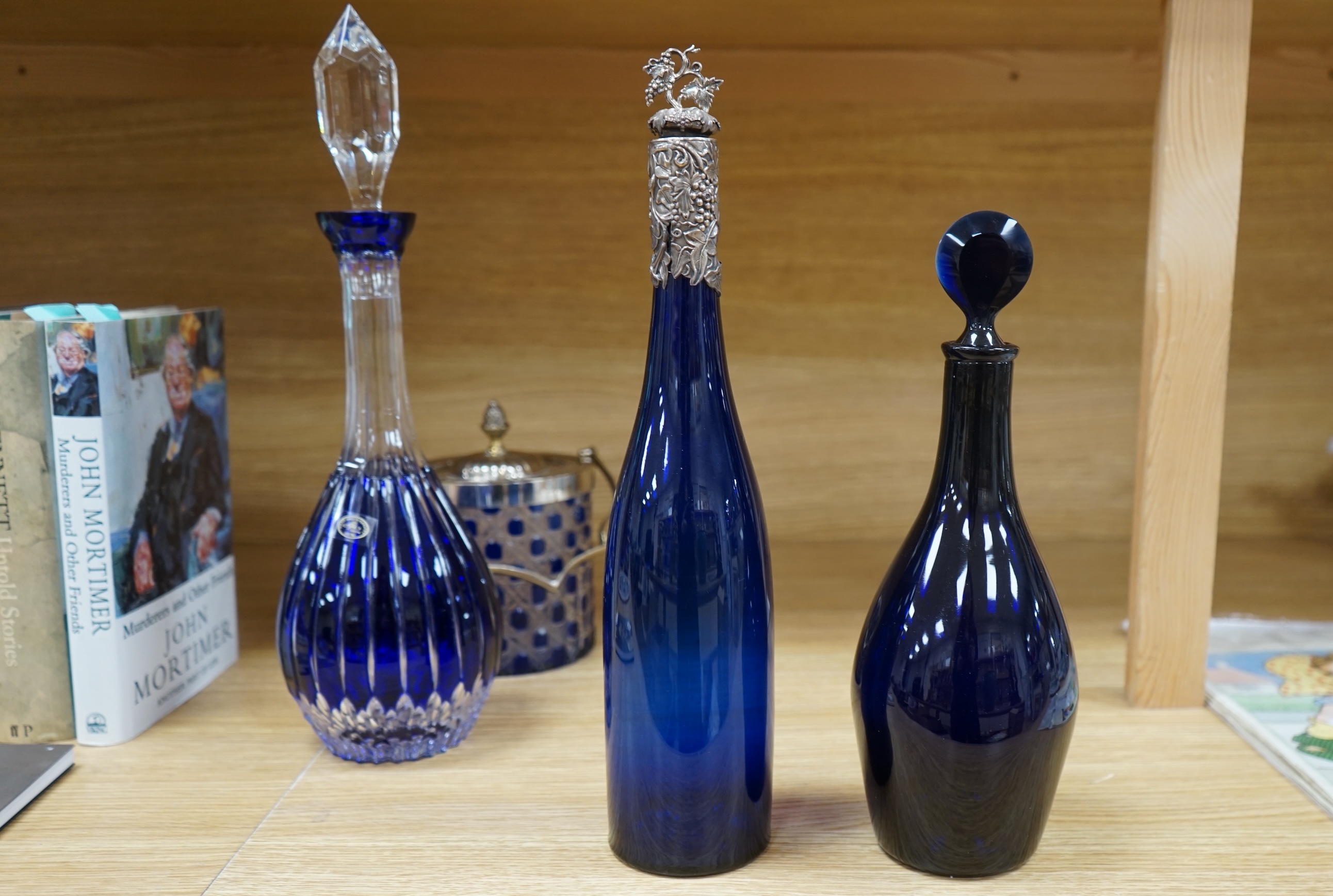 A collection of blue glassware comprising a late 18th century Bristol blue glass decanter and tear drop stopper, 30cm, a mid 19th century electroplate mounted blue glass decanter, a later Hungarian decanter and a similar